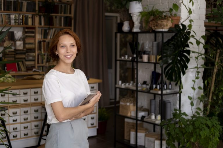 Woman holding tablet in workshop illustrates blog "Are Business Owners Covered by Workers Compensation?"