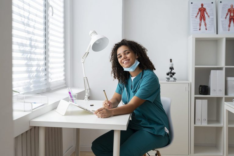 Smiling woman wearing scrubs in white office