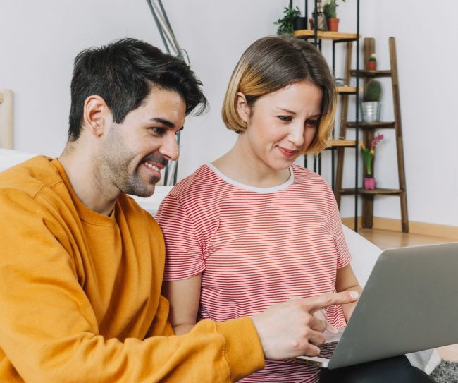 man-woman-laptop-living-room-fp Man and woman looking at laptop illustrate blog "How Does Indexed Universal Life Insurance Work?"
