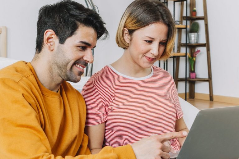 Man and woman looking at laptop illustrate blog "How Does Indexed Universal Life Insurance Work?"