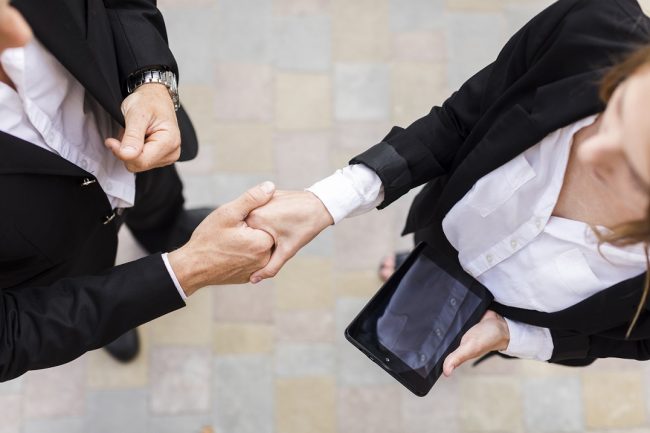 handshake-business-freepik Woman and man shake hands.